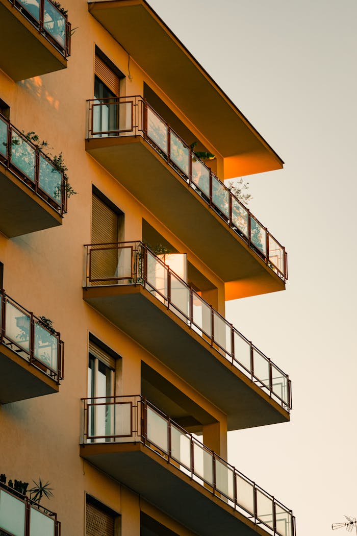 A striking view of a modern apartment building with balconies at sunset, showcasing urban architecture.